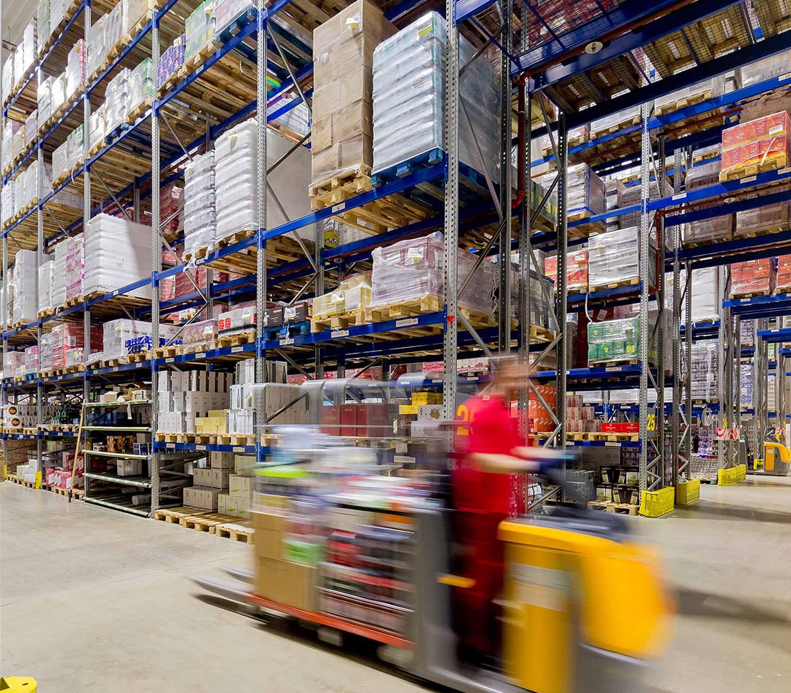 A man operating a forklift in a warehouse, transporting goods efficiently.